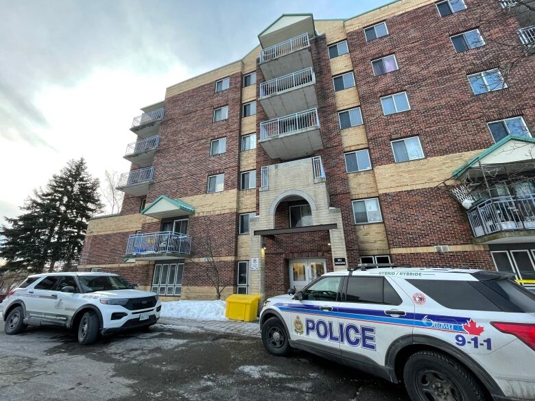 A police vehicle outside a 5 of 6-storey building.