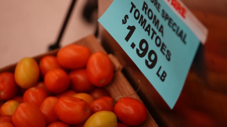 Roma tomatoes are shown for sale with a price tag of $1.99 per pound