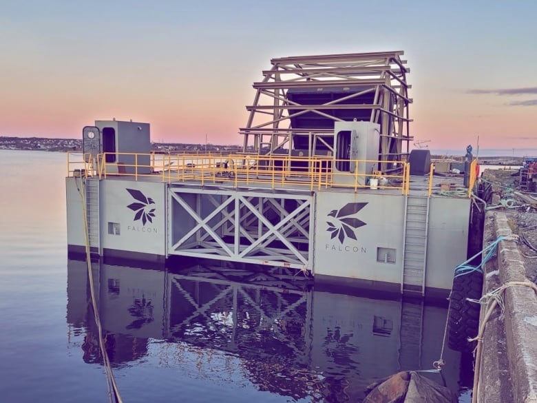 A building is next to a wharf in the water.