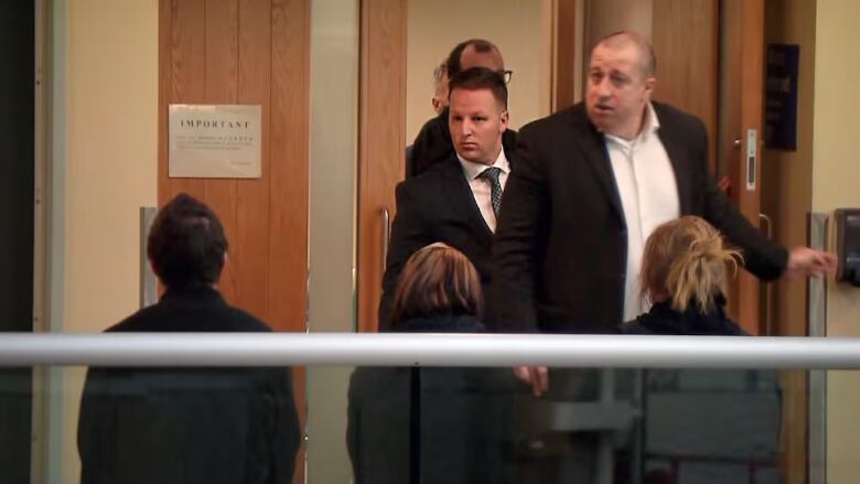 Men entering a court room.