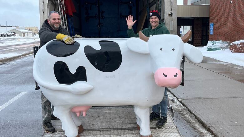 Cows statue loaded into a truck.