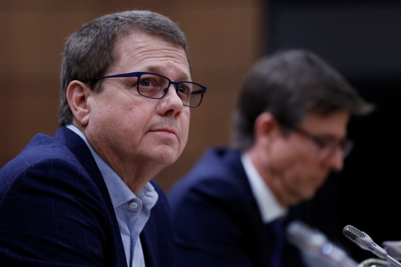 Michael Medline is shown in the foreground, and Galen Weston in the background. Both mean appeared at a parliamentary committee probing grocery prices on March 8 2023.