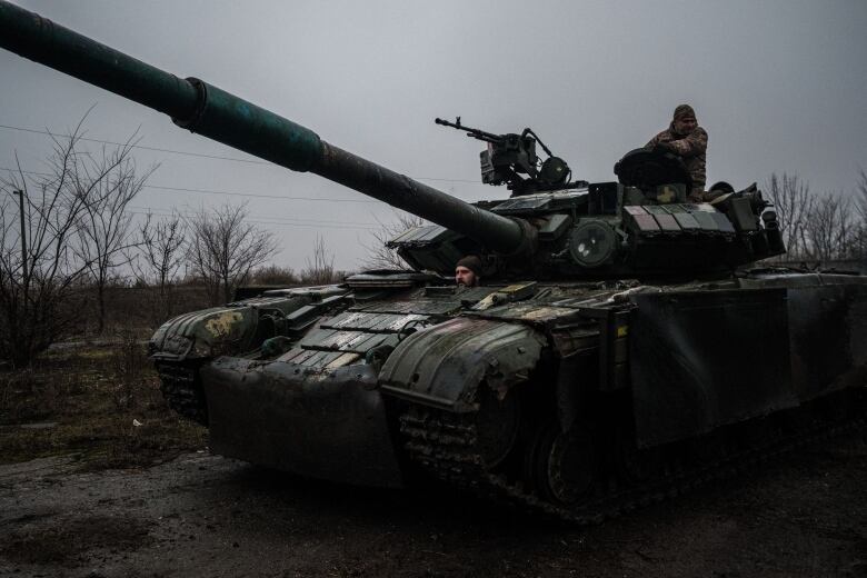 Ukrainian soldiers, travelling via tank, move along a road going from Chasiv Yar to Bakhmut.