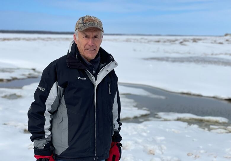 Arthur Melanson standing in front of ocean, sand dunes and creek