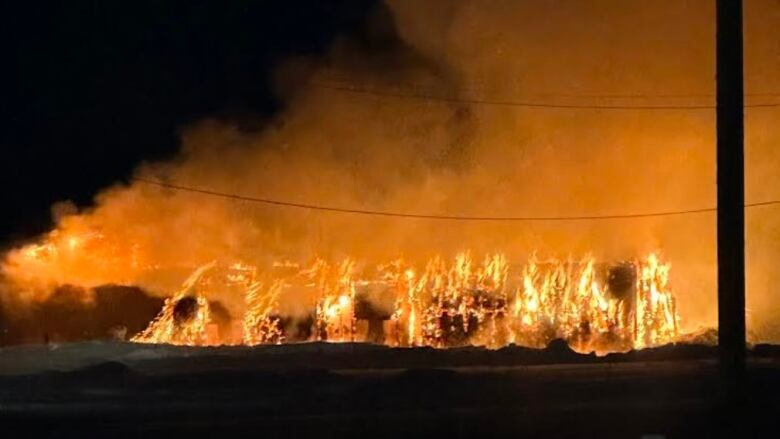 A building is engulfed in flames at night.