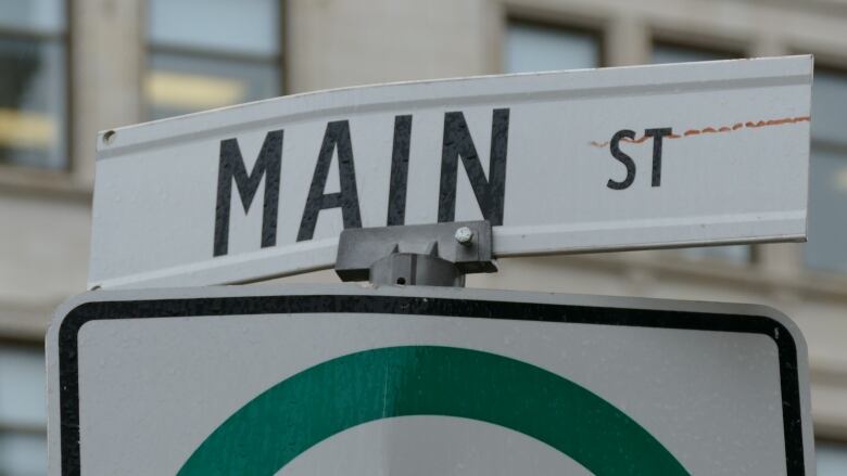 A closeup shows a street sign reading 