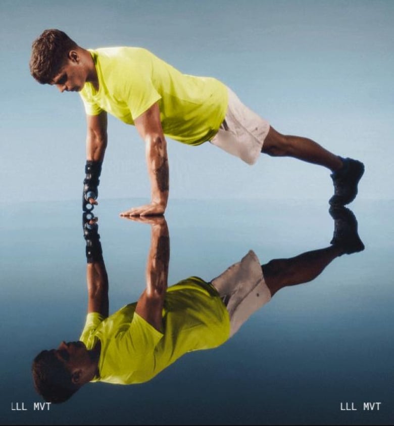 A man with one leg does a pushup on a reflective shiny floor.