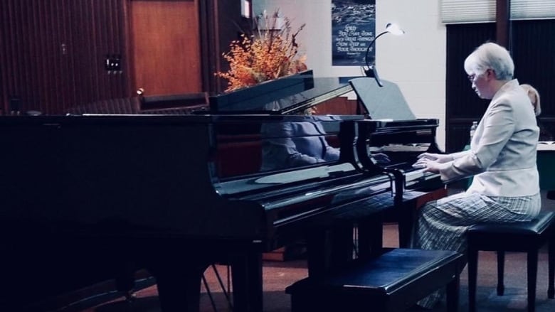 A woman plays on a grand piano.