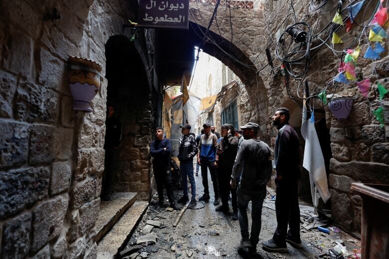 People gather outside a house in an old city. 