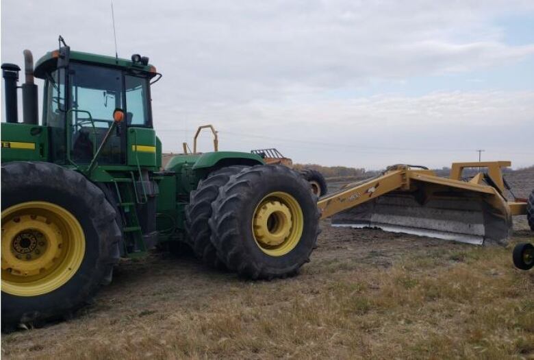 A farm tractor is shown in a grassy field.