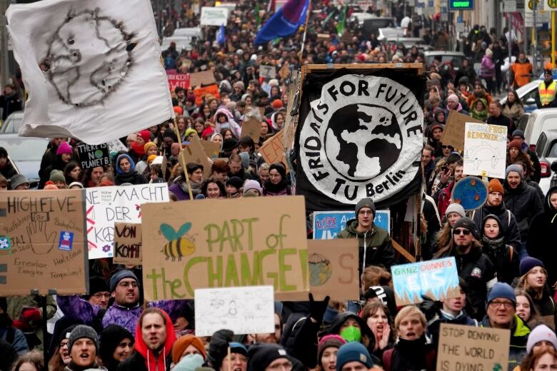 Demonstrators hold up signs calling for action on climate change.