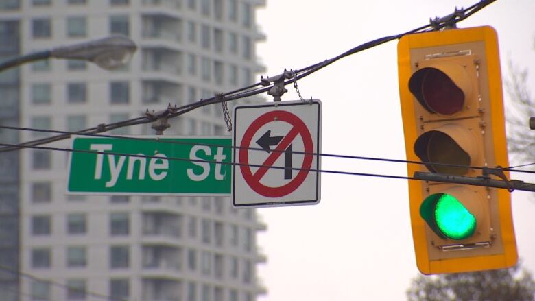 A green street light and a Tyne Street sign.