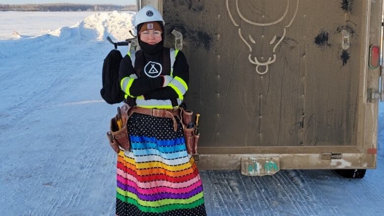 Shylah stands outside a trailer in a ribbon at a worksite. 