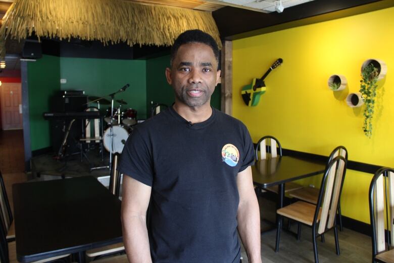 Neville Hamilton poses for a photo in the dining room of his restaurant. 