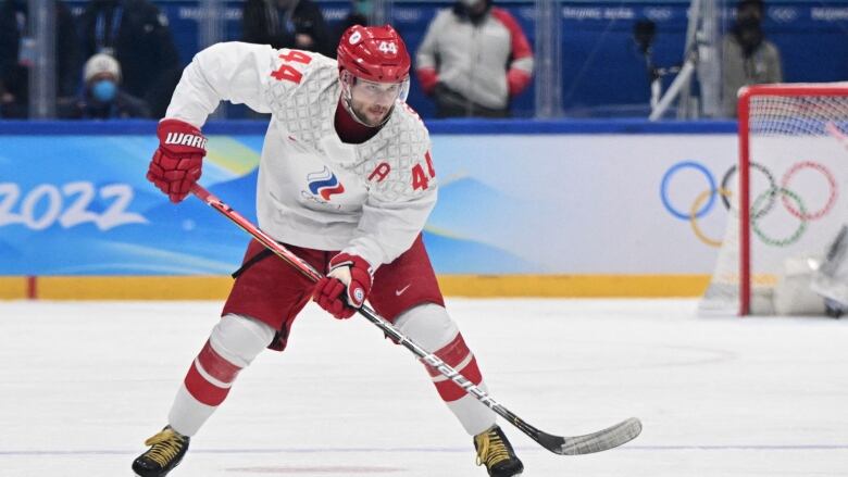 A hockey player skates with the puck.