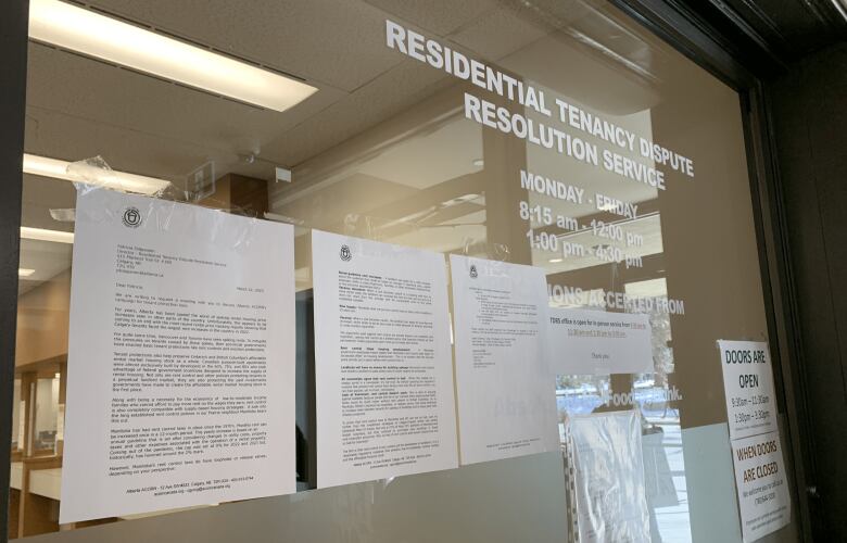 Pieces of paper taped on glass at the Residential Tenancy Dispute Resolution Service