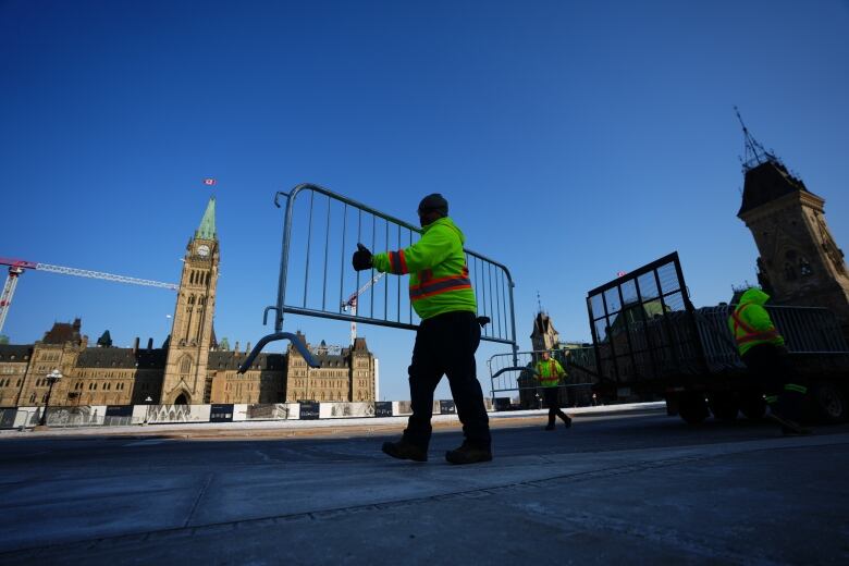 Workers set up a temporary fence in front of a legislature.