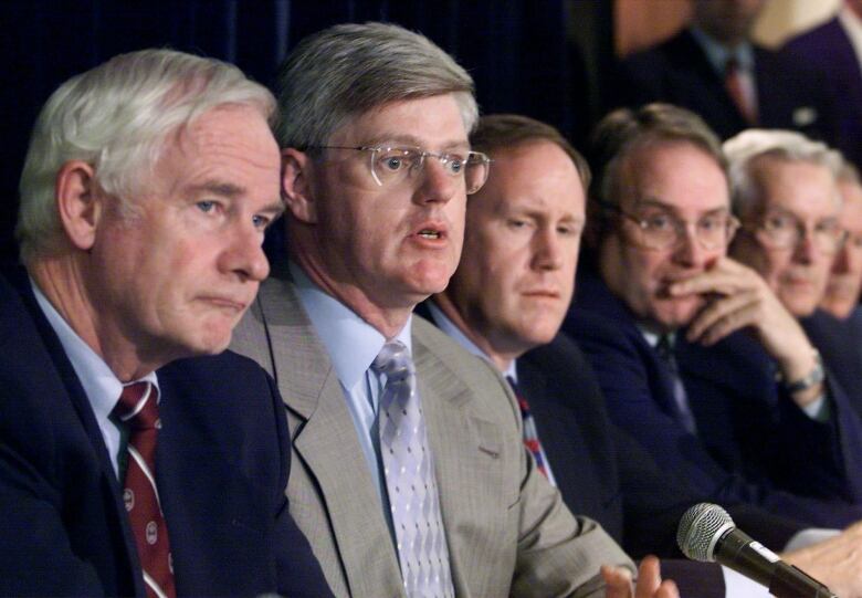 Then-Industry Minister John Manley (second from left) answers reporters' questions at a news conference on federal funding for professional hockey teams in Toronto Monday June. 28, 1999. With Manley (from left to right) are Chairman David Johnston, NHLPA executive director Bob Goodenow, President of the Toronto Maple Leafs Ken Dryden, and Calgary Flames president Harley Hotchkiss.