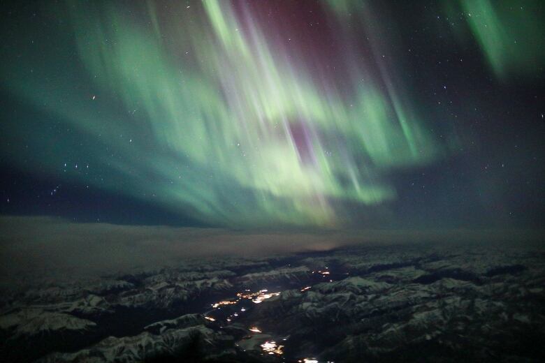 The northern lights over mountain peaks at high elevation