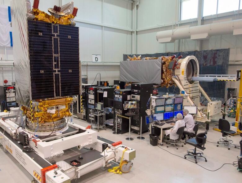 Technicians put the final touches on two of three Radarsat Constellation Mission satellites at the MDA facility on June 21, 2018 in Montreal. The satellites, which will be launched in late 2018, will be doing Maritime surveillance, ecosystem monitoring and disaster management.