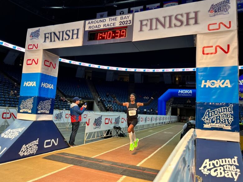 A man smiles as he approaches the finish line of a race.