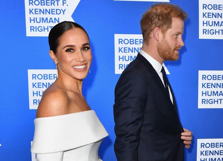 A man and a woman are shown in formal wear walking.