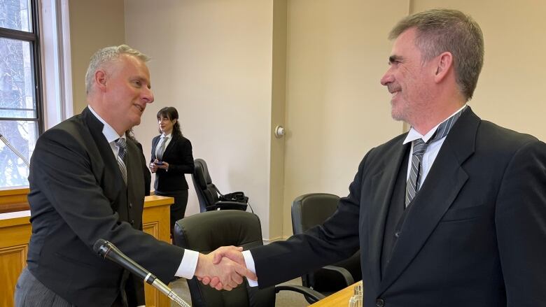 two lawyers shake hands.