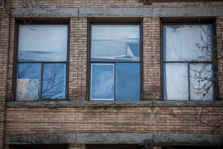 A rooming house seen from the outside with a closeup of three windows.