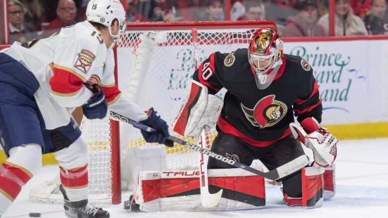 The Ottawa goaltender makes a save on a Florida player, who is standing right outside of the crease.