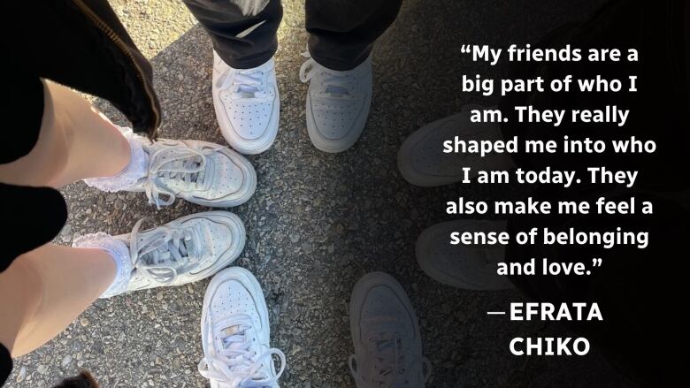 Four girls stand in a circle. The camera captures their white shoes. 