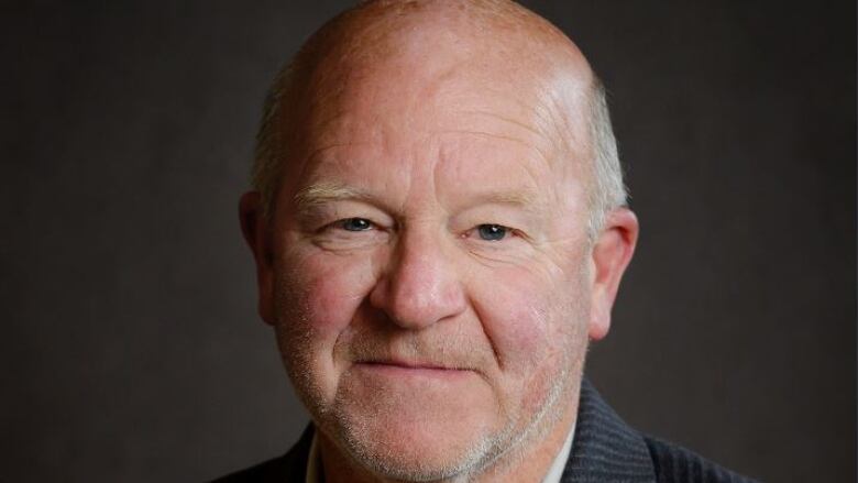 A head and shoulders photo of a man with a slight smile on his face.