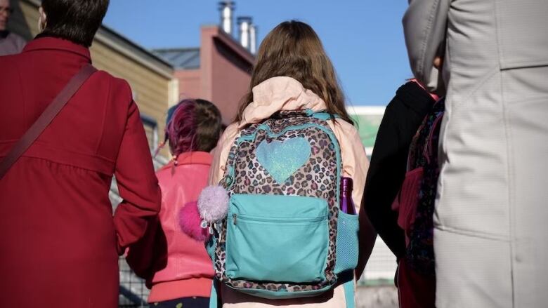 The back of a student in front of'cole des Trois-Soleils