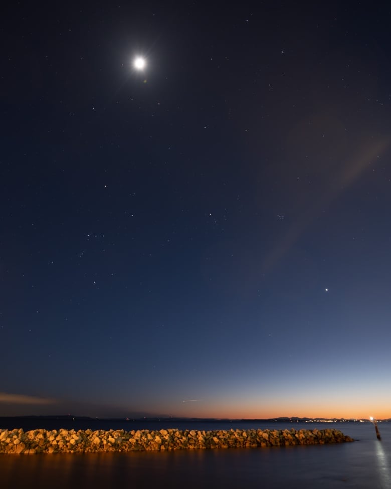 Mars, Venus, the Pleiades star cluster also known as the Seven Sisters, and Orion are visible over the White Rock Pier.