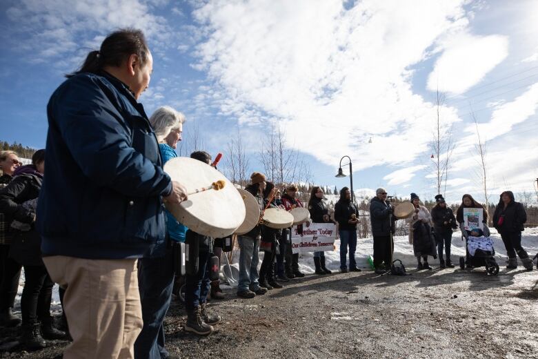 Man with drum and crowd of people.