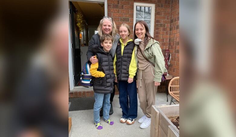 A family poses in front of a house doorstep.