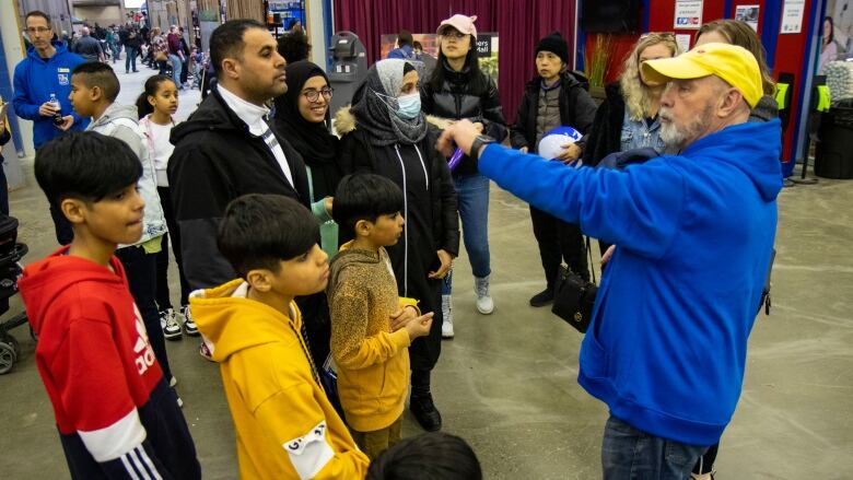 A group of people are given a tour of a petting zoo.