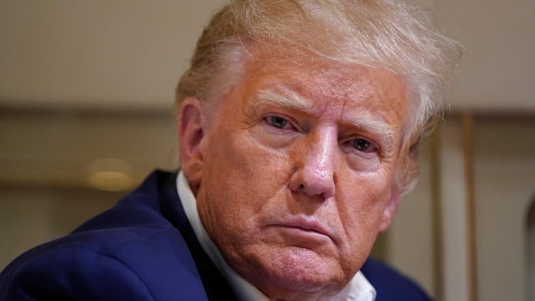 Former President Donald Trump listens as he speaks with reporters while in flight on his plane after a campaign rally at Waco Regional Airport, in Waco, Texas, Saturday, March 25, 2023, while en route to West Palm Beach, Fla.