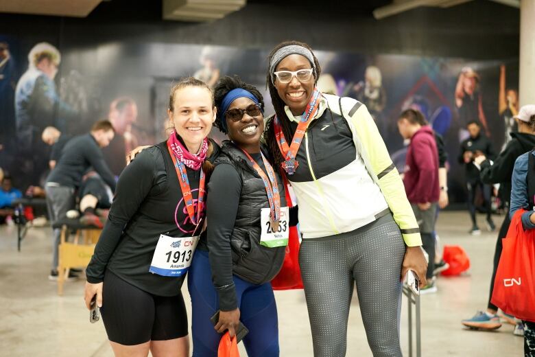 Three people with medals on smile, standing together.