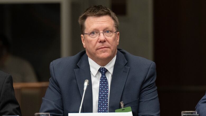 A photograph of forme Canadian Security Intelligence Service Michel Juneau-Katsuya giving evidence at a parliamentary committee. 