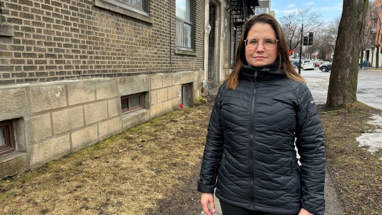 A woman stands outside looking at the camera. 