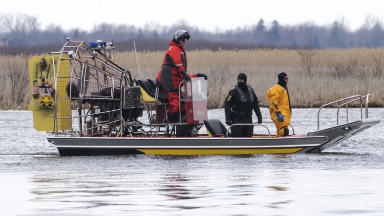 Searchers on a boat in the water. 