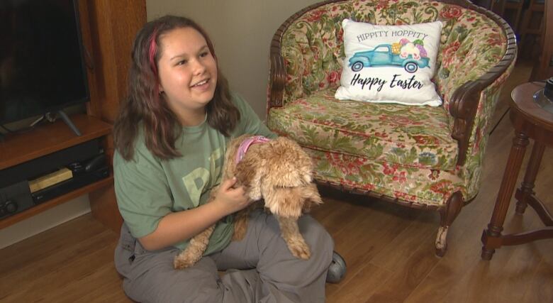 A 12-year-old girl holds onto a pet.