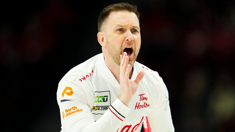 Men's skip directs his teammates down the ice during a curling match.