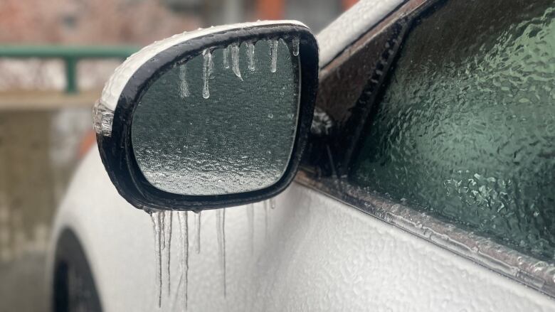 Icicles hang from a light-coloured vehicle's side window.