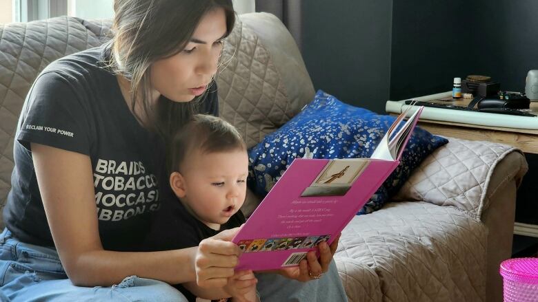 An Indigenous mother reads to her daugher 