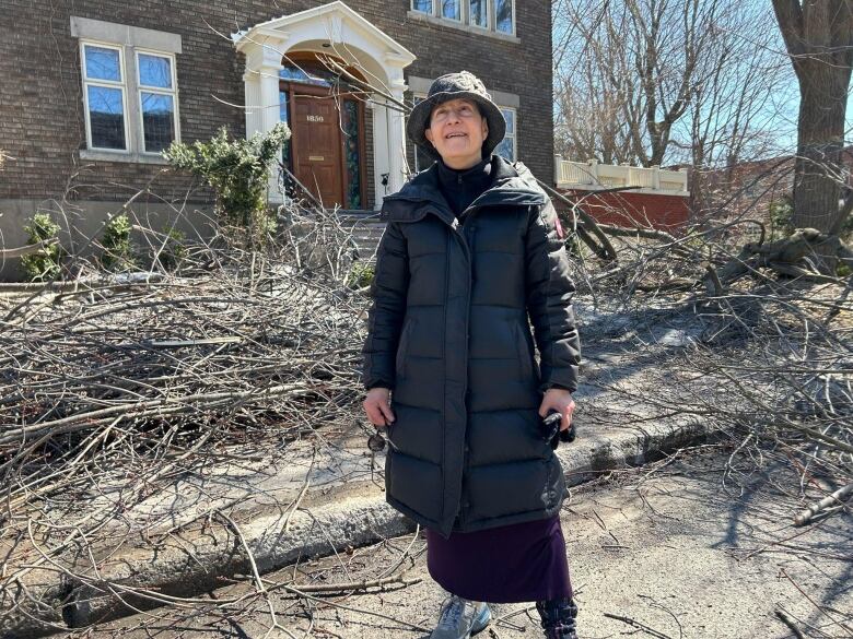 A woman stands in front of her house.