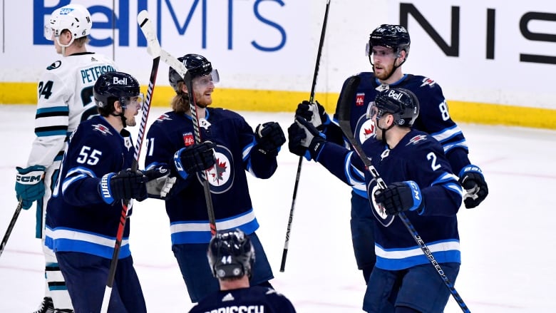 A group of five Winnipeg players celebrate together.