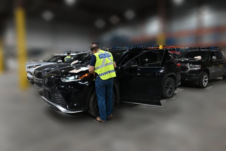 police officer writes something on an SUV