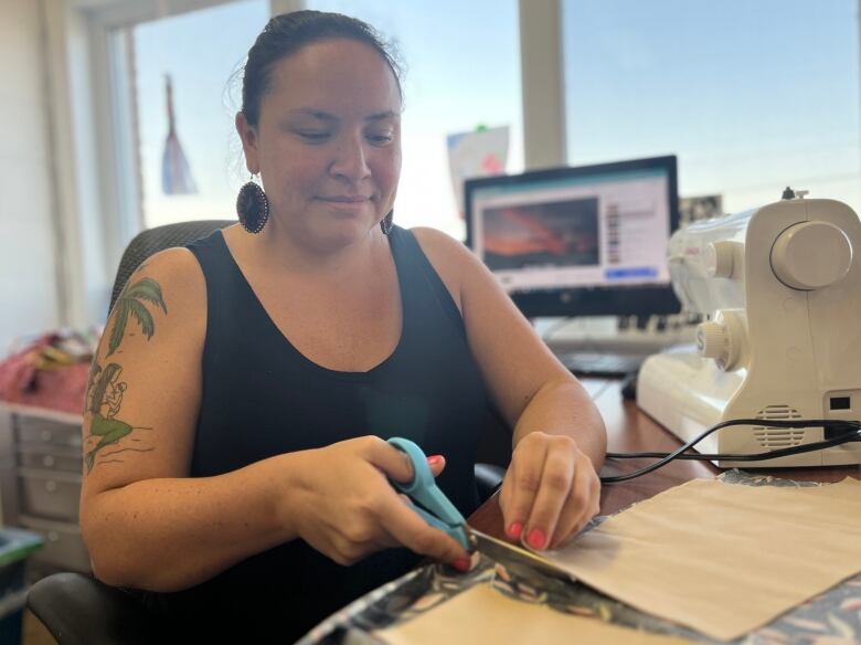  Cheyanne McComber cuts fabric for the shirt she's making for her son. 