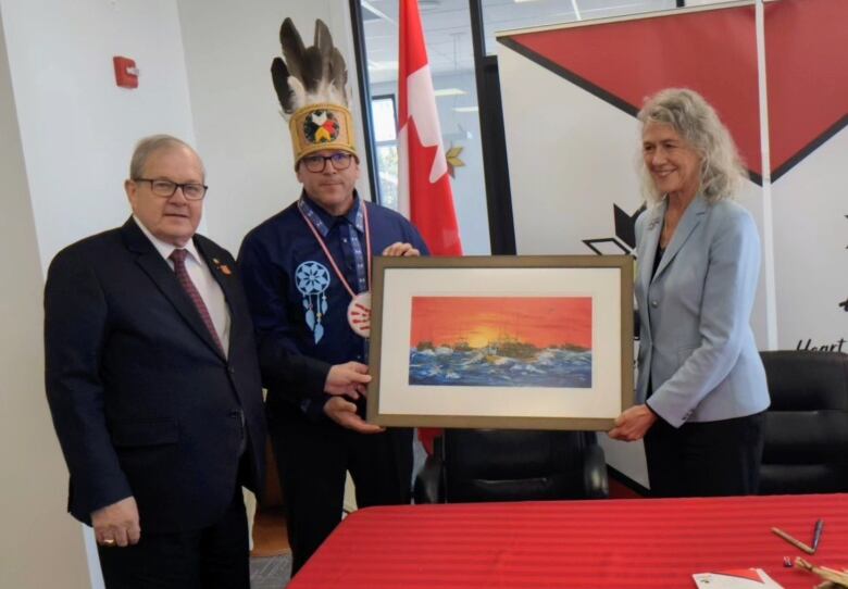 Man and woman in business suits and man in Mi'kmaw headdress.  